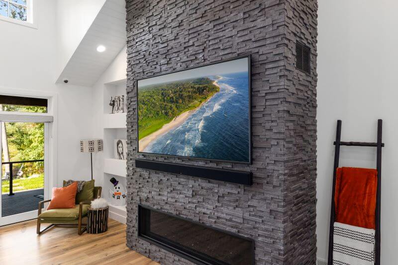 Large TV mounted on stone fireplace